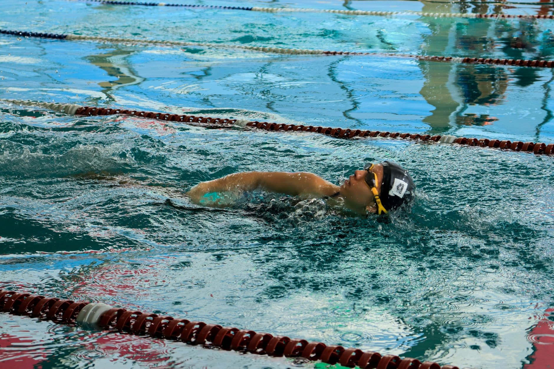 Swimmer taking a breath mid-freestyle stroke in an indoor lane pool